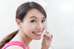 Woman holding Invisalign tray