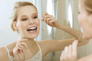 a young woman flossing her teeth