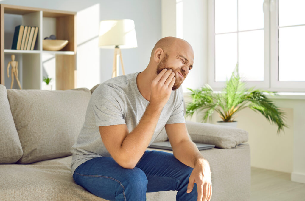 Male holding mouth in pain